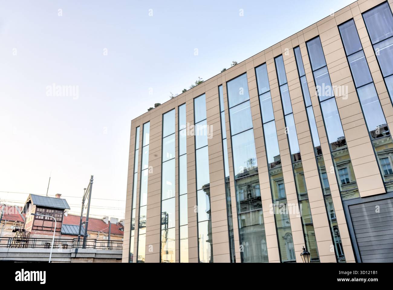 Moderno edificio per uffici in vetro e metallo a Praga, Repubblica Ceca, con pinne verticali affilate che si innalzano contro un cielo mattutino limpido. Foto Stock