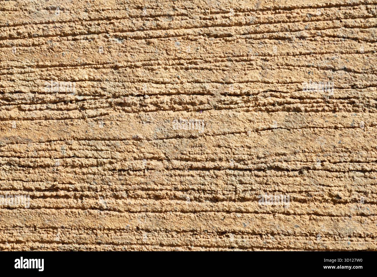 La superficie presenta un colore marrone intenso con scanalature profonde e linee parallele. La luce del sole ne migliora la consistenza, creando interesse visivo per un ambiente esterno sc Foto Stock