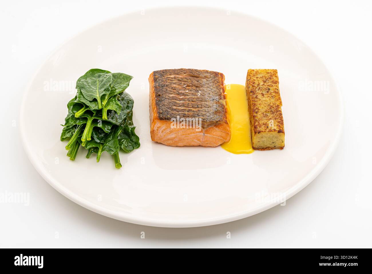 Filetto di salmone scottato servito con spinaci saltati e croquette di patate Foto Stock