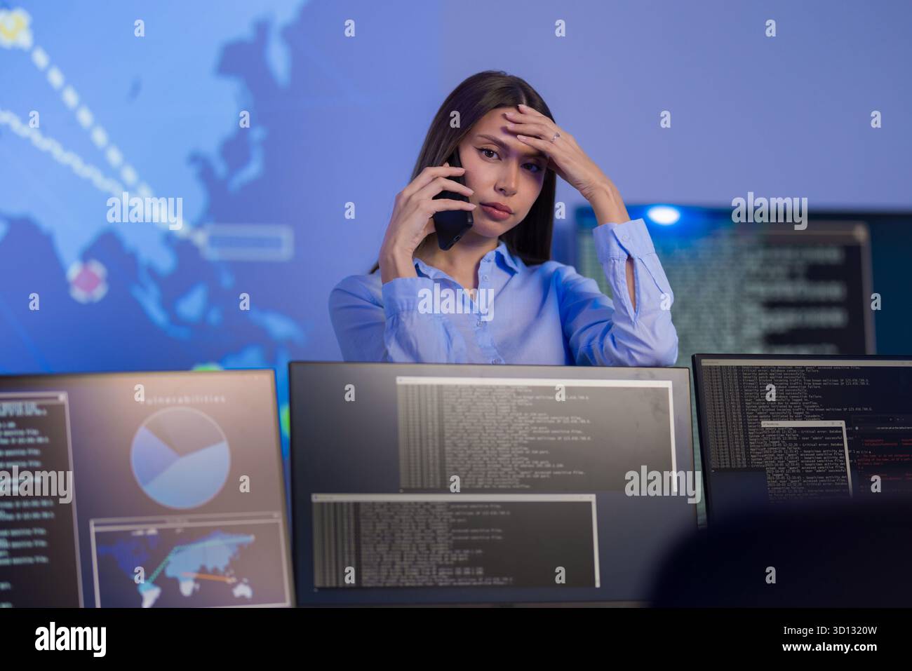 Analisti preoccupati che monitorano gli incidenti di sicurezza informatica in ambiente SOC su più schermi Foto Stock