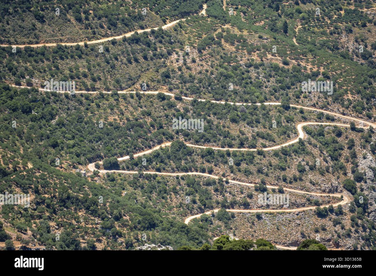 Una strada tortuosa si snoda attraverso le montagne di Creta, mostrando una splendida vegetazione Foto Stock