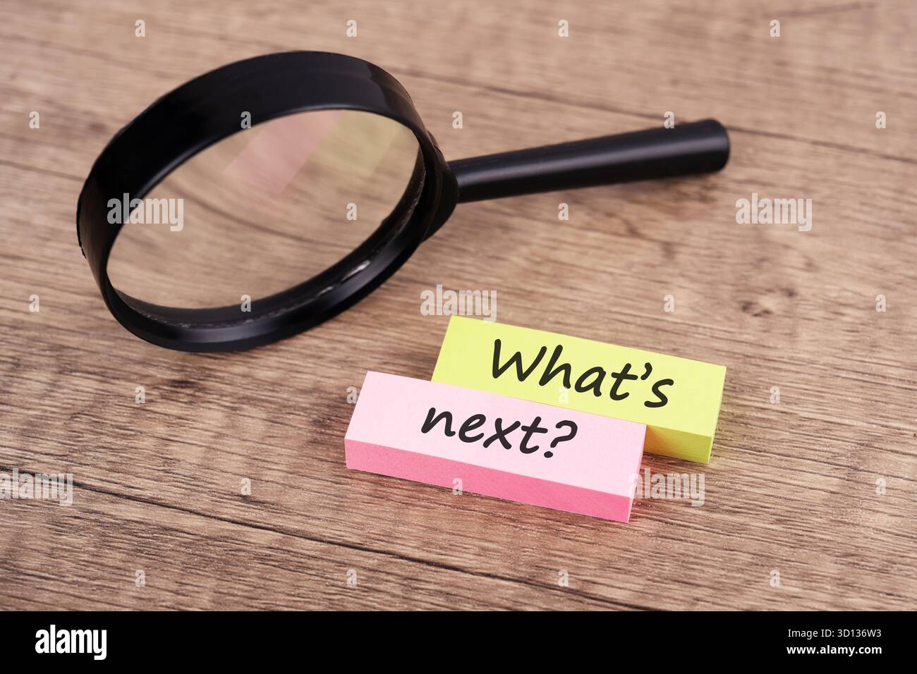 Lente d'ingrandimento e nota cartacea con testo What's Next business concept Foto Stock