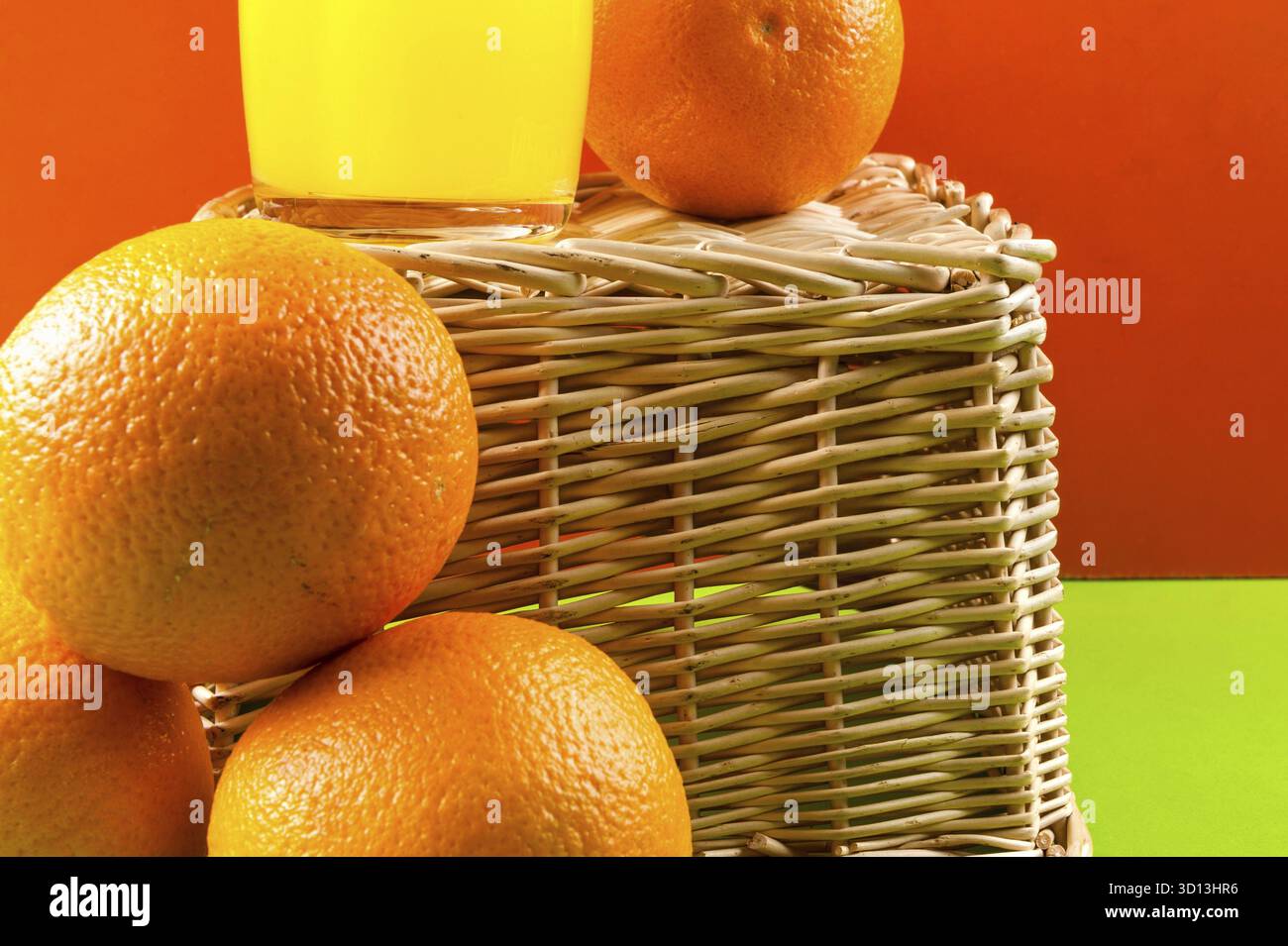 Bicchiere di succo con arance su sfondo rosso Foto Stock