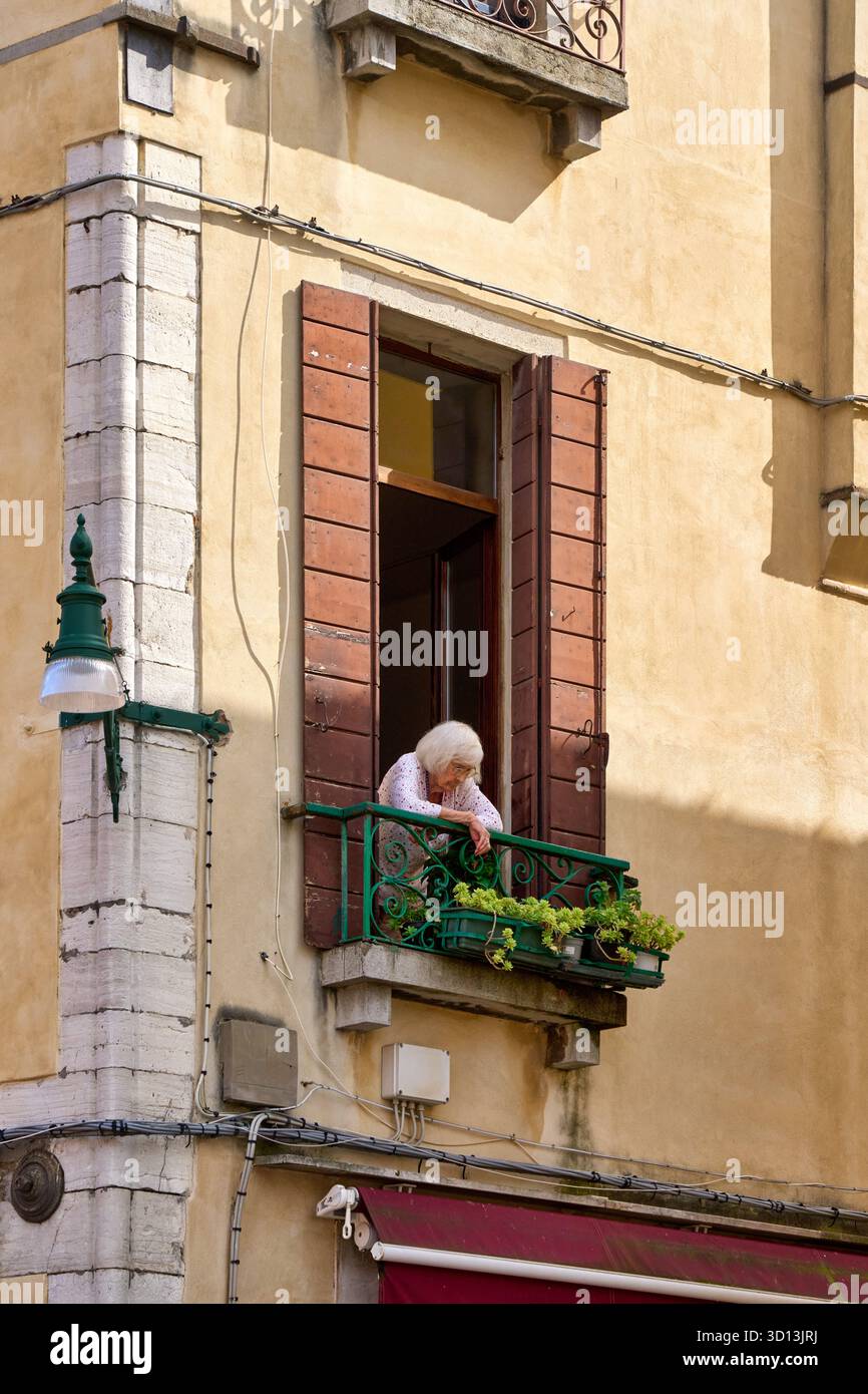Signora che guarda fuori da una finestra, Venezia, Venezia, Veneto, Italia, Europa Foto Stock