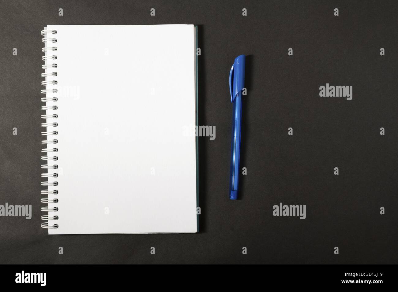 Notebook con penna su sfondo scuro Foto Stock