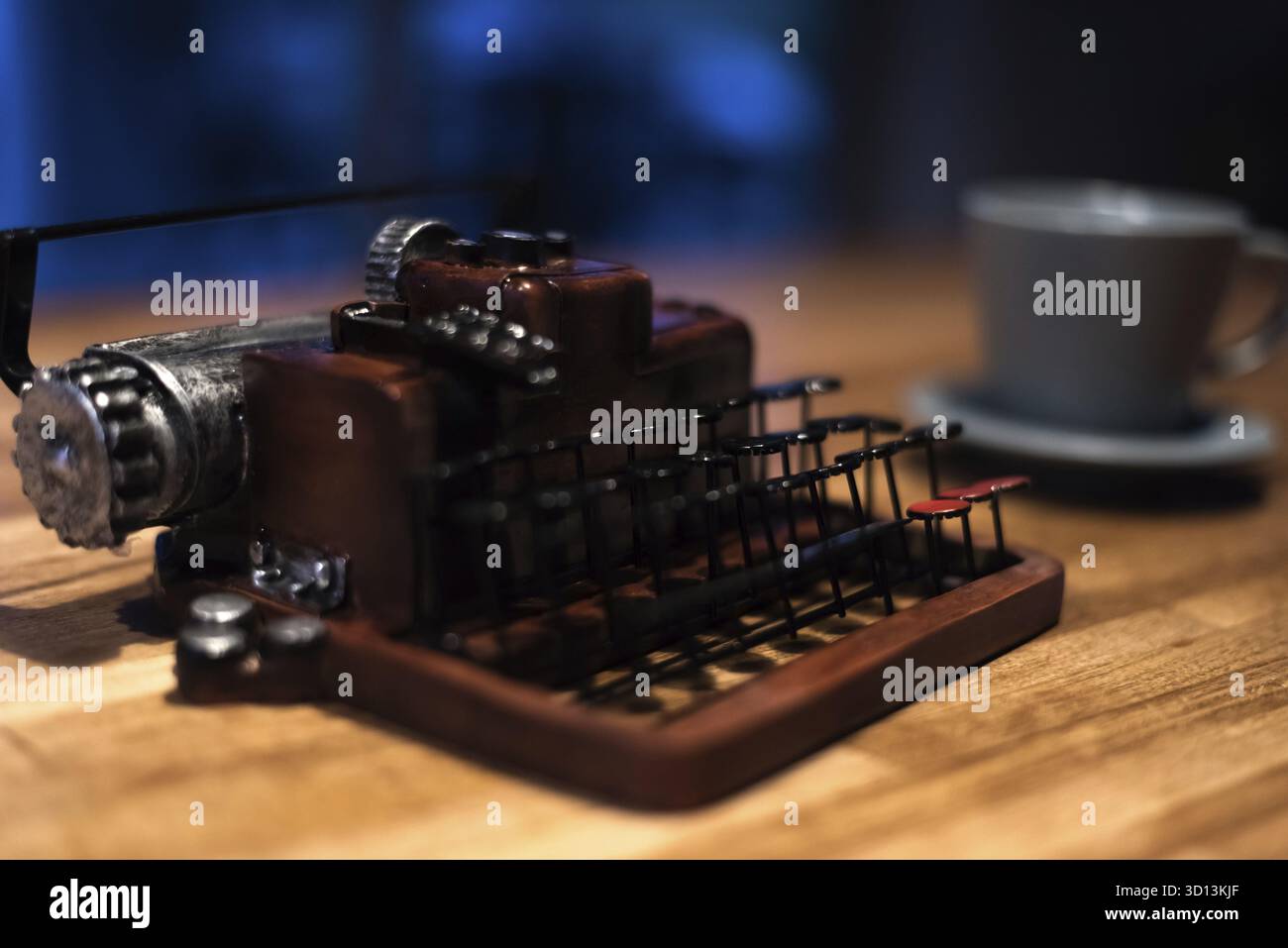 Macchina da scrivere con una tazza di caffè sulla scrivania a casa la sera Foto Stock