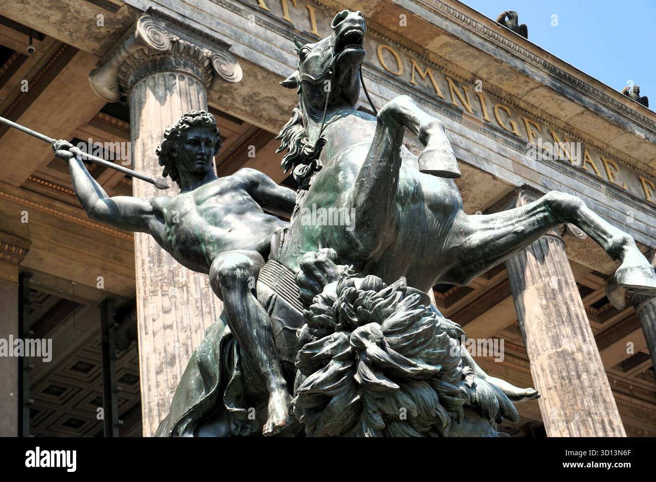 Statua in bronzo di un guerriero su un cavallo che caccia un leone con una lancia di fronte all'ingresso del Museo Altes di Berlino, Germania Foto Stock