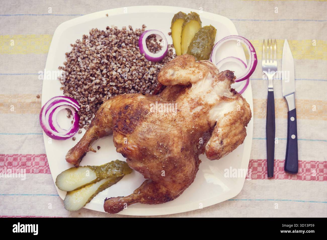 Cotta nel forno a condimenti il pollo con il grano saraceno. Cucina domestica. Il pollo al forno la carcassa. Pollo con grano saraceno, cipolle e cetrioli Foto Stock