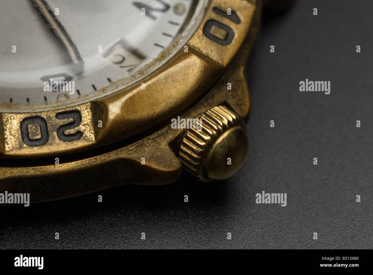 Primo piano della corona di un vecchio orologio in ottone su sfondo scuro Foto Stock