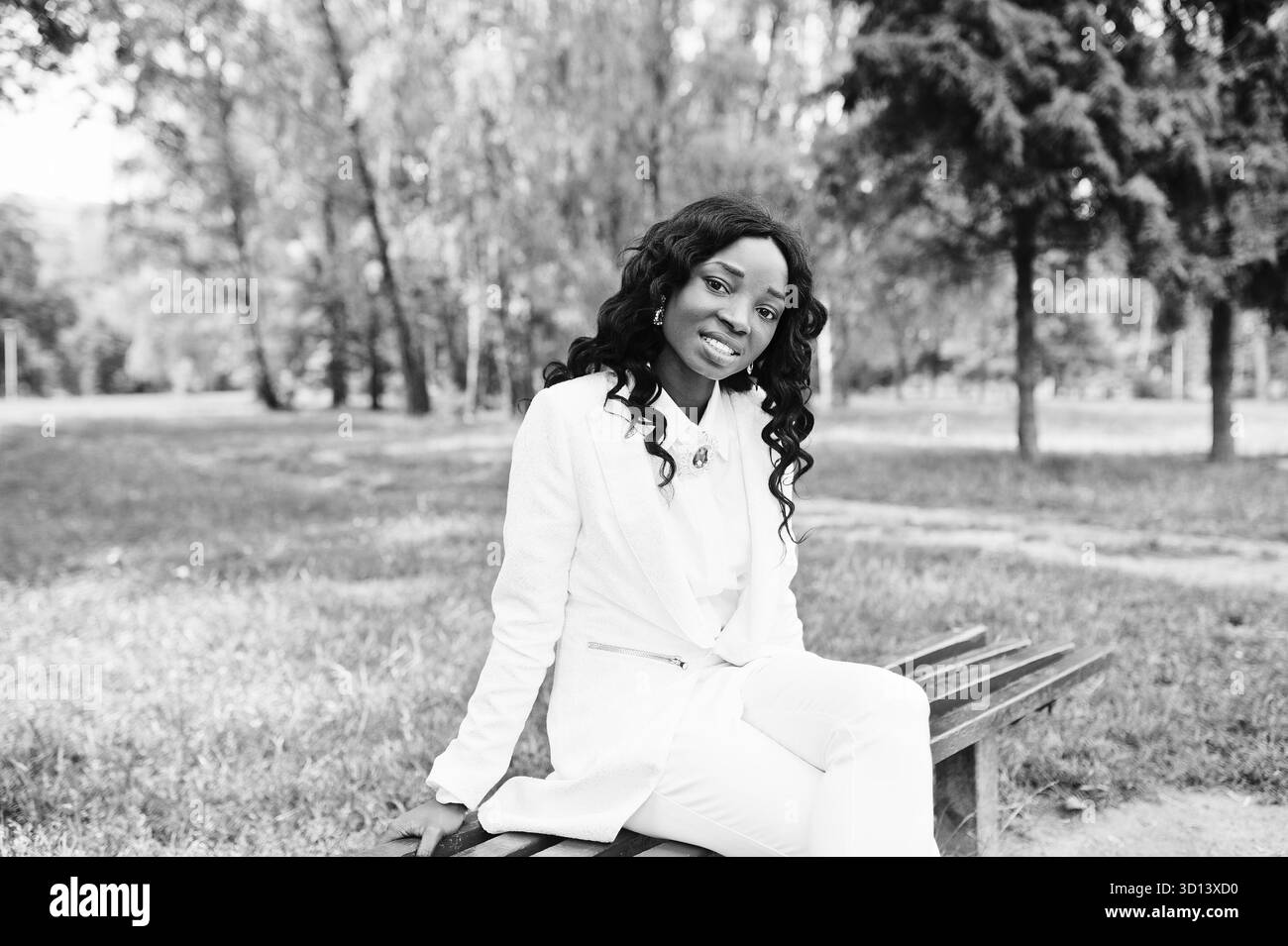 Ritratto di pretty nero americano africano ragazza seduta sul banco a green park Foto Stock