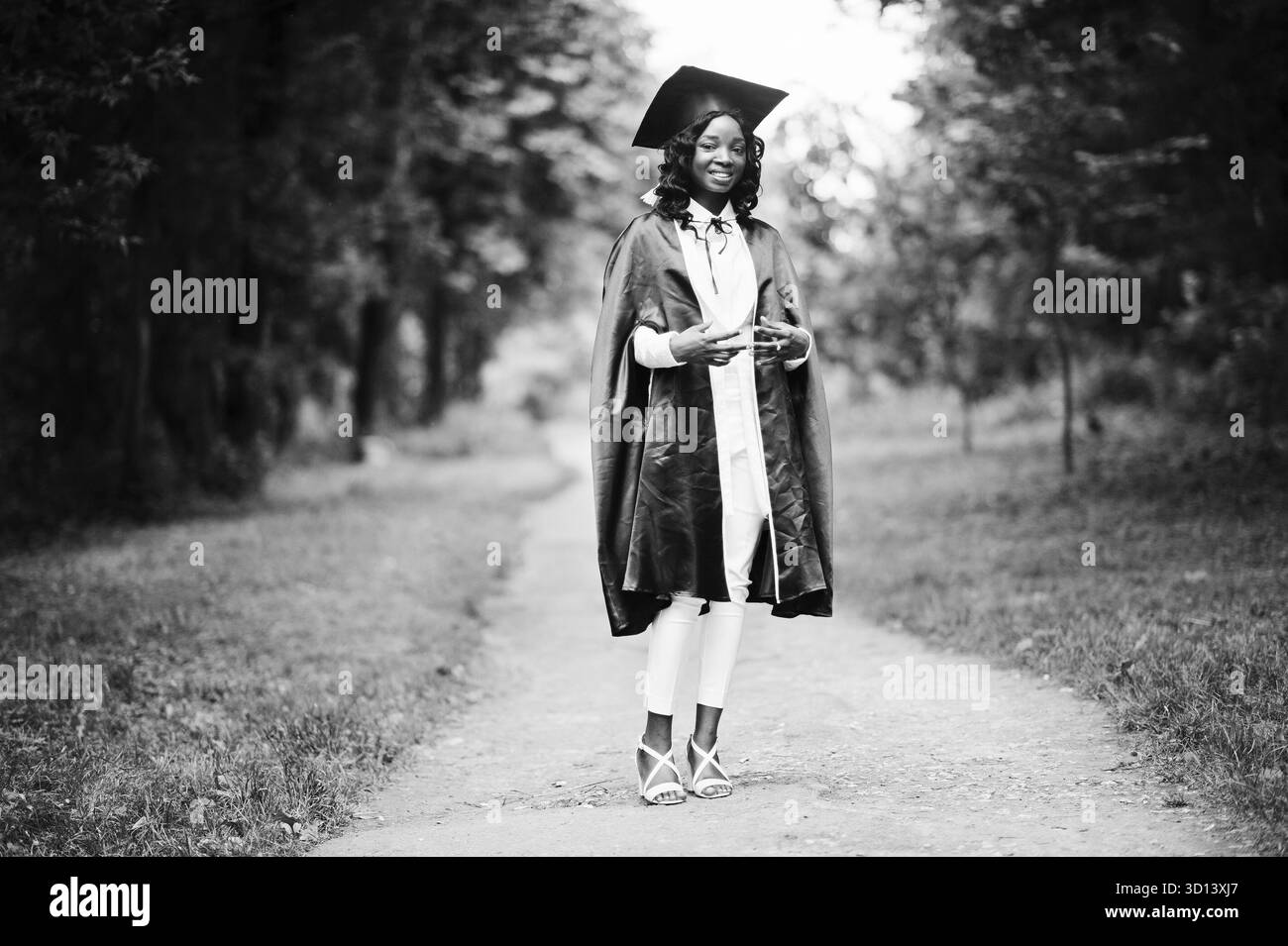 Felice bella africano nero ragazza americana con hat e camice laureati Foto Stock