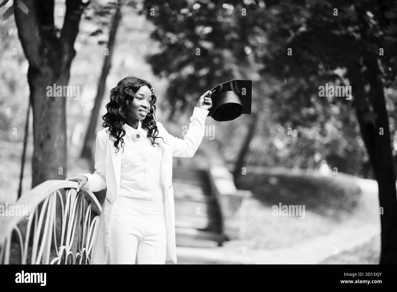 Felice bella africano nero ragazza americana con hat laureati Foto Stock