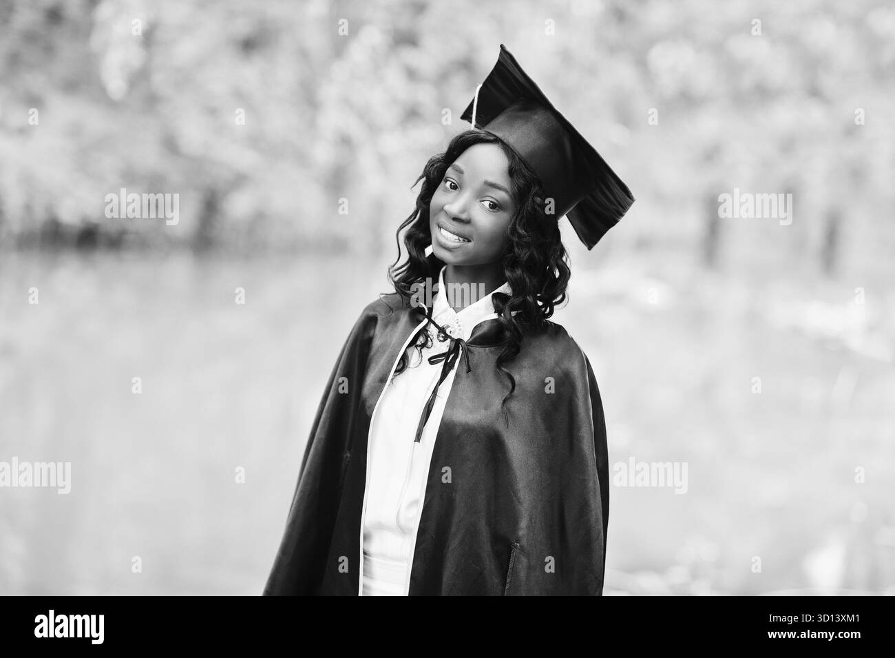 Felice bella africano nero ragazza americana con hat e camice laureati Foto Stock