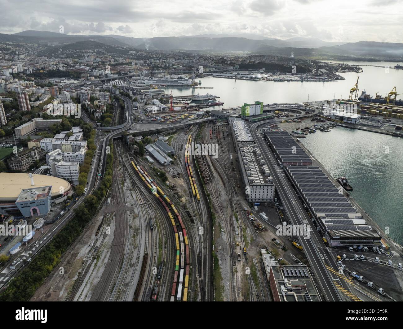 Veduta aerea del vivace porto, con la sua complessa rete ferroviaria e banchine in contrasto con il Mare Adriatico, Trieste, Friuli-Venezia Giulia, Italia. Foto Stock