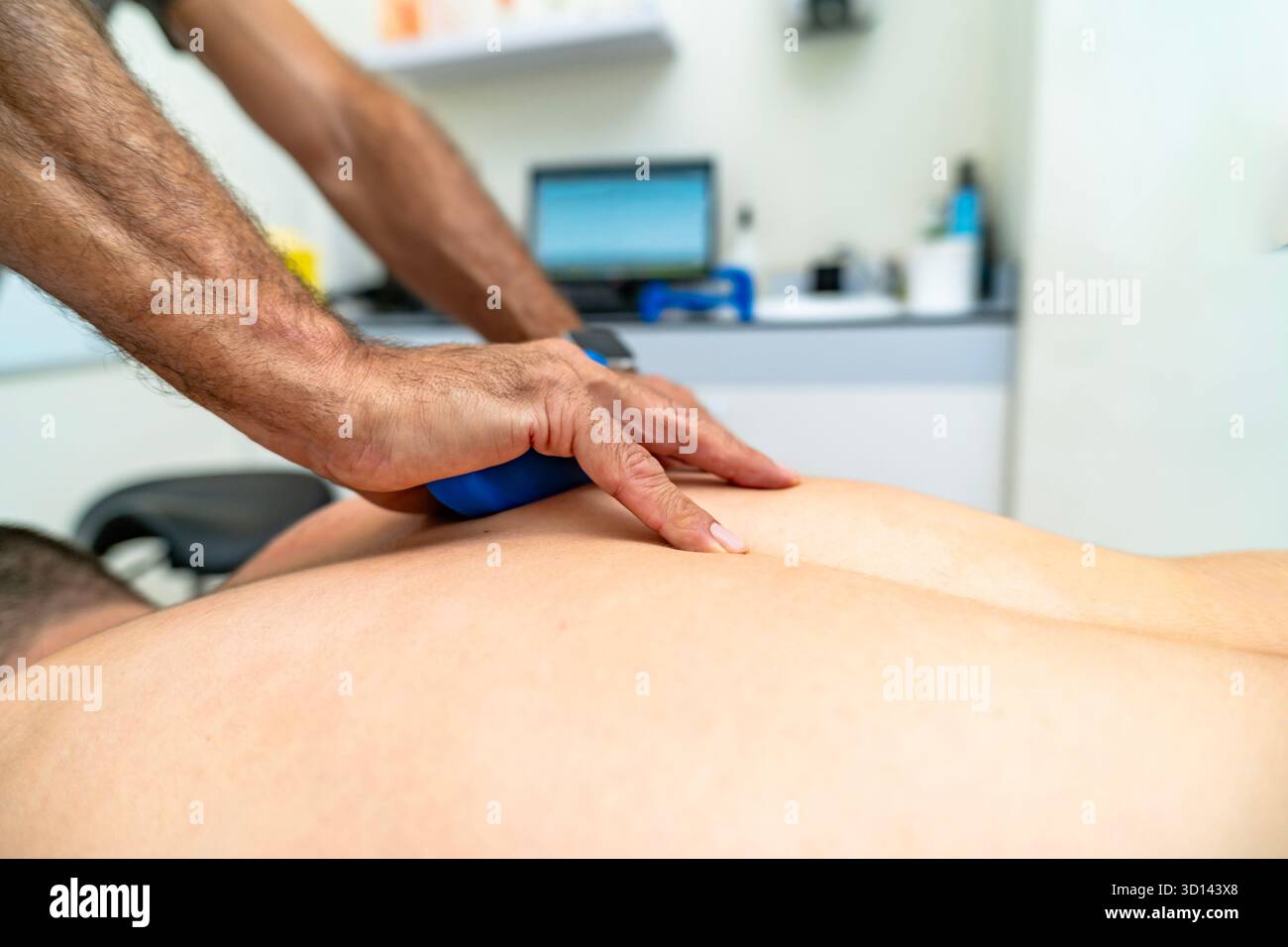 Fisioterapista professionista che applica un massaggio terapeutico a un paziente in clinica per alleviare il dolore Foto Stock