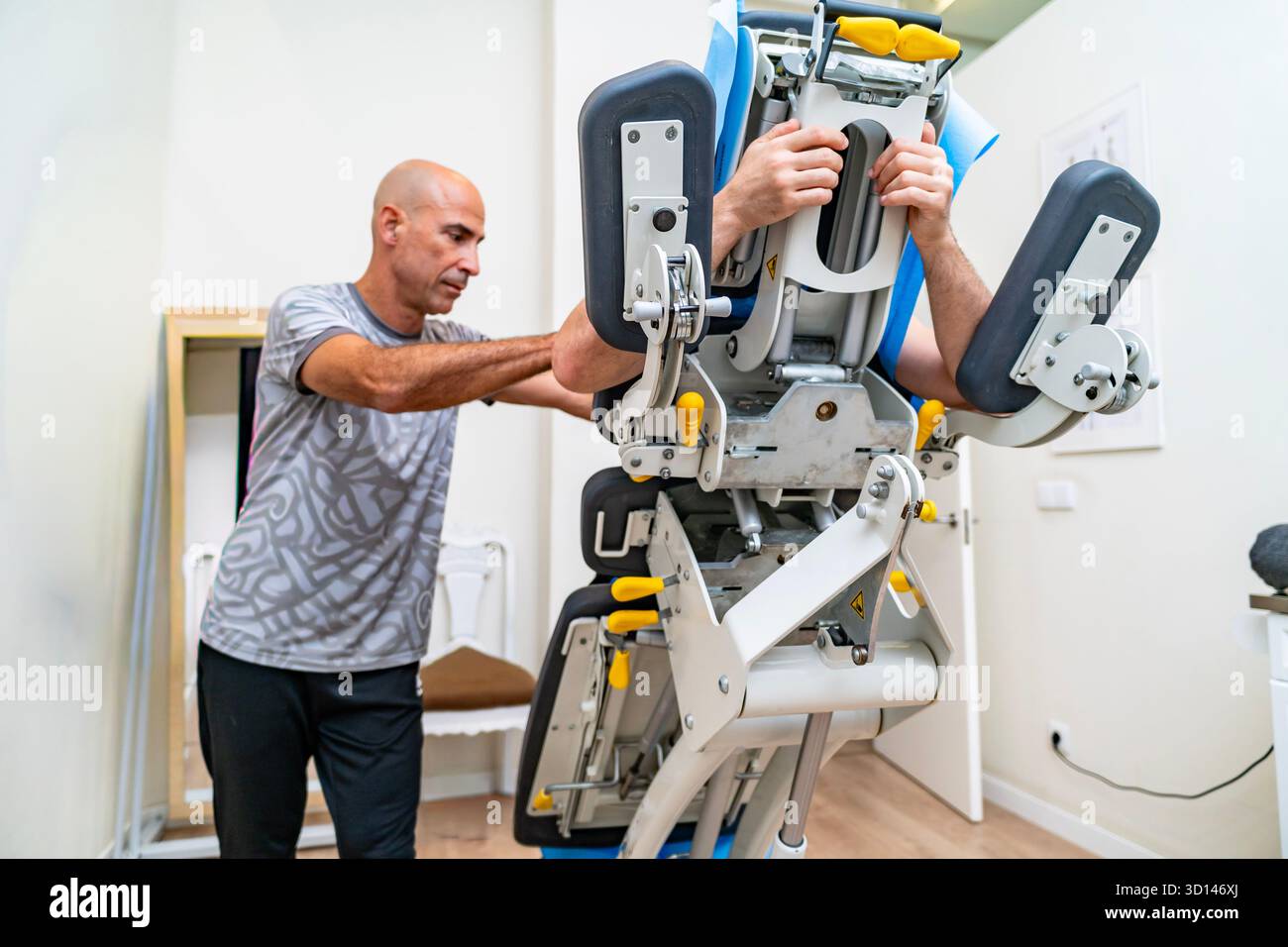 Fisioterapista che guida un paziente nell'esecuzione di esercizi su un dispositivo specializzato per la riabilitazione del pavimento pelvico Foto Stock