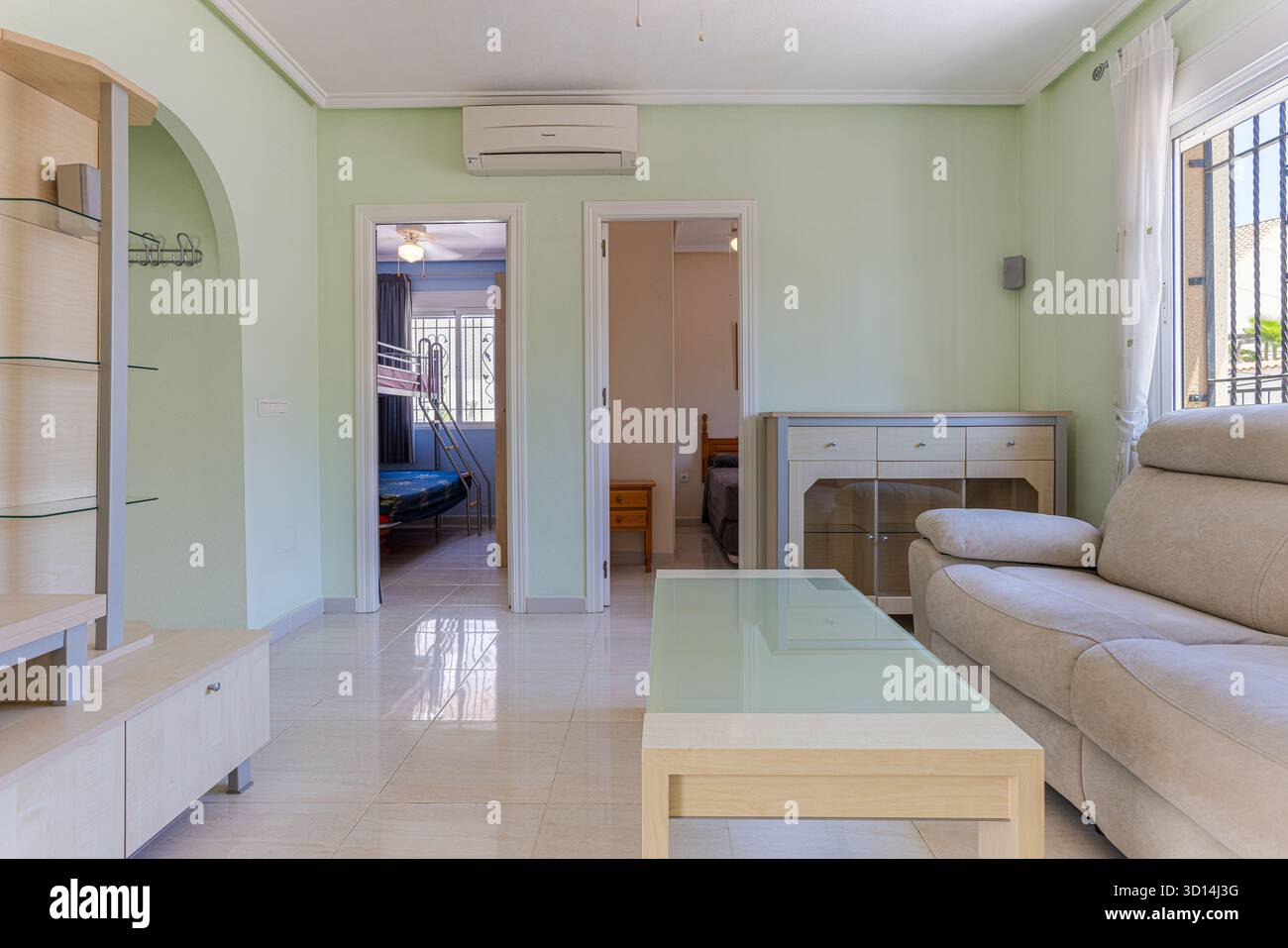 Comoda zona soggiorno con mobili neutri, pareti color pastello e vista sui bambini e sulle camere da letto principali Foto Stock