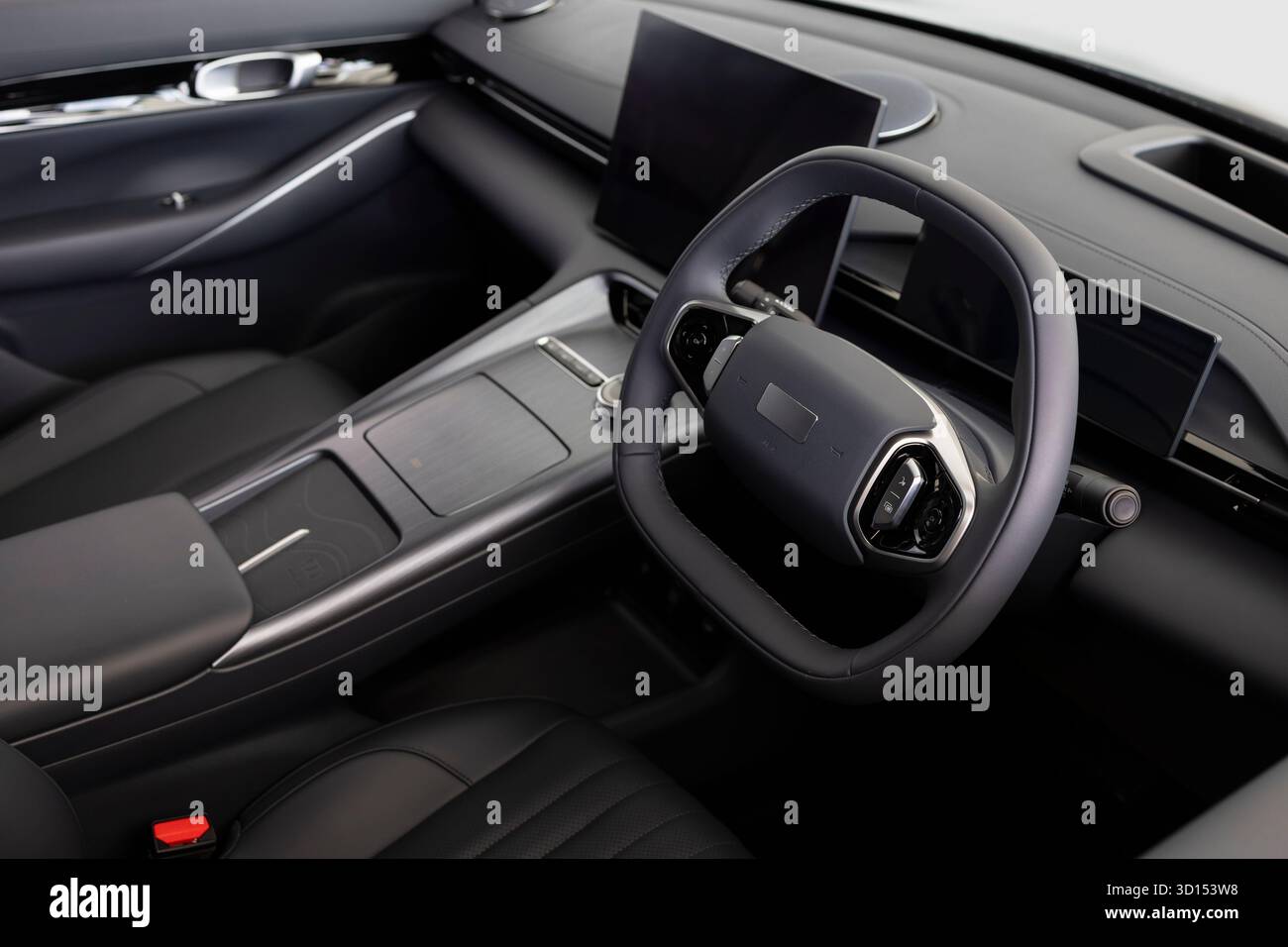 Primo piano di un abitacolo moderno e lussuoso incentrato sul volante e sul cruscotto. Concetto di tecnologia dei veicoli, design premium e settore automobilistico Foto Stock