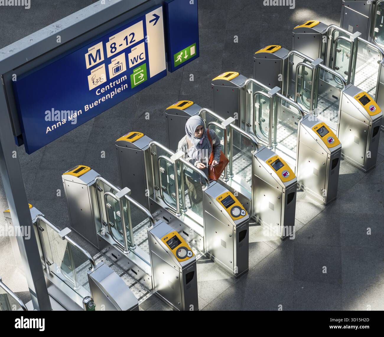 L'Aia, Paesi Bassi - 6 agosto 2017: Persone e bambini al check point OV della stazione centrale l'Aia alla luce del sole Foto Stock