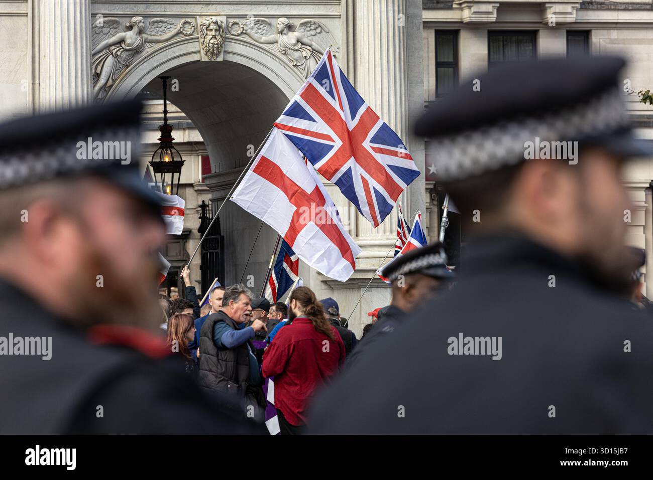 Gli agenti di polizia monitorano i partecipanti e mantengono l'ordine pubblico in una manifestazione di protesta di estrema destra a londra, Regno Unito . Foto Stock