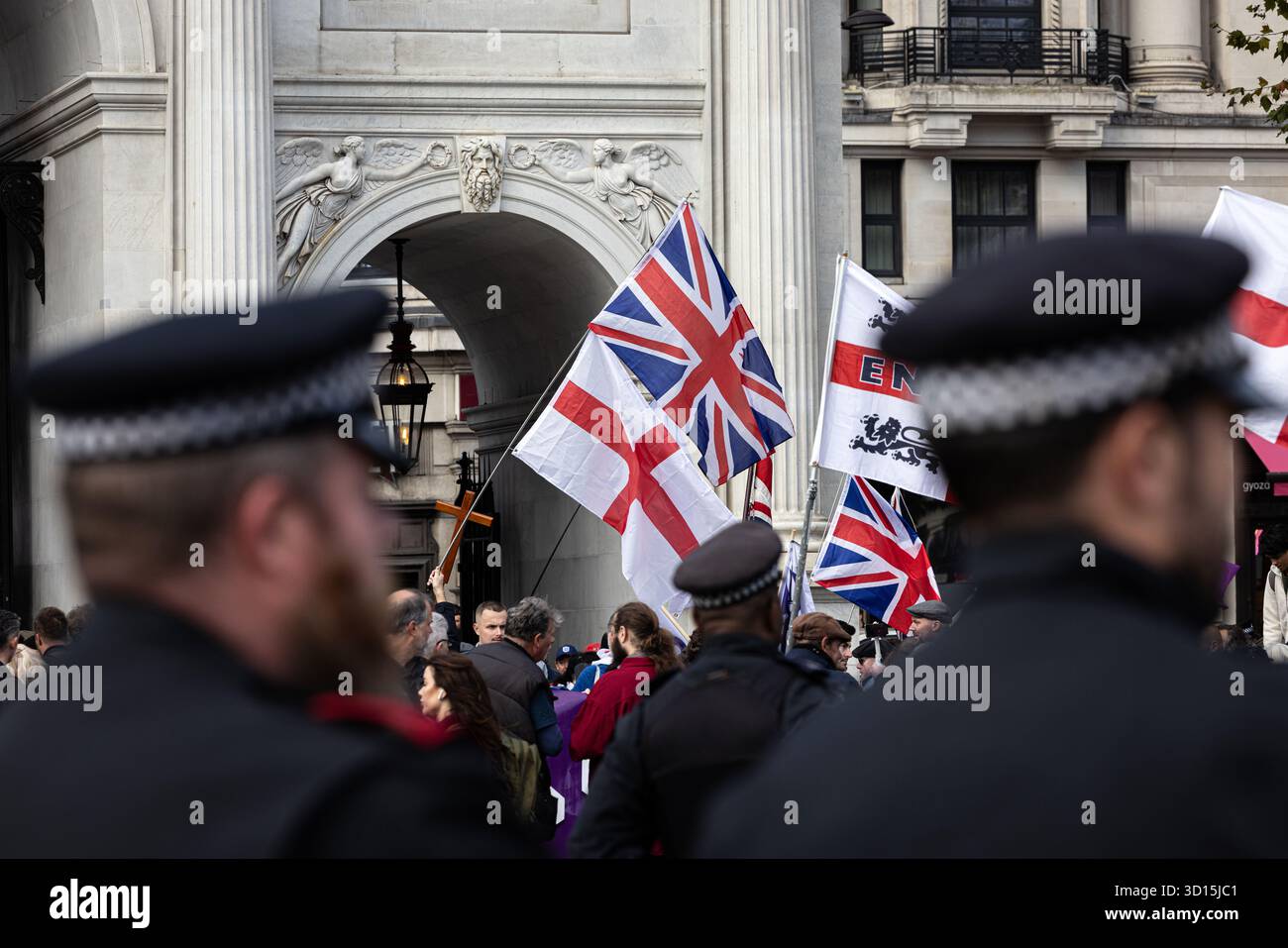 Gli agenti di polizia monitorano i partecipanti e mantengono l'ordine pubblico in una manifestazione di protesta di estrema destra a londra, Regno Unito . Foto Stock