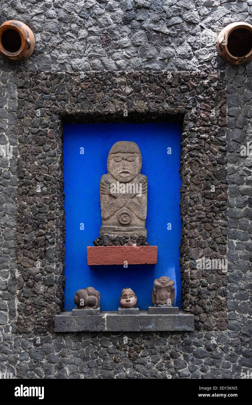 Sculture in pietra pre-ispanica in una nicchia muraria blu nella casa di Frida Kahlo, la Casa Azul, Coyoacán, città del Messico. Foto Stock