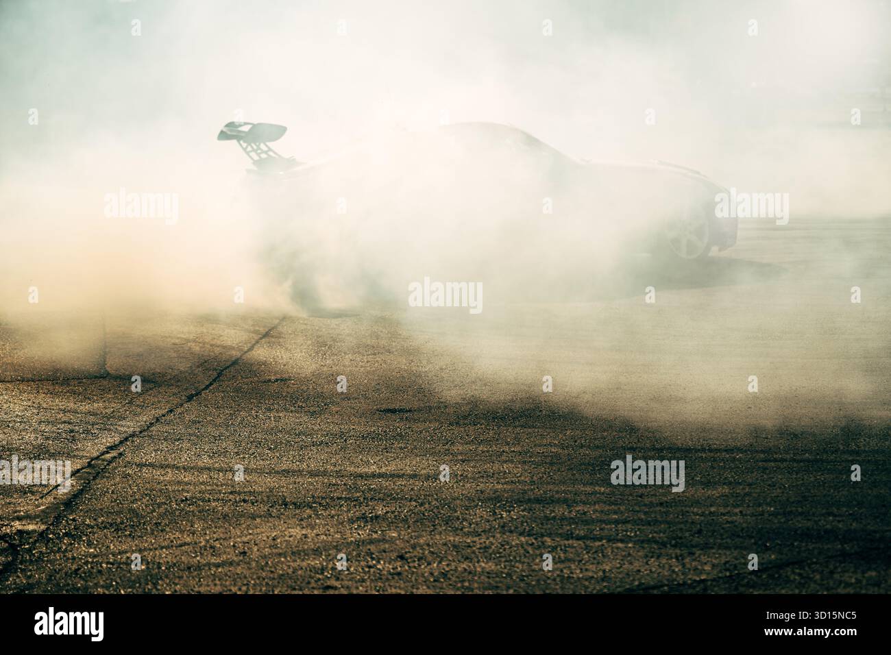 Le auto si spostano sulla strada asfaltata, creando un'enorme nuvola di fumo durante gli sport motoristici. Messa a fuoco selettiva. Foto Stock