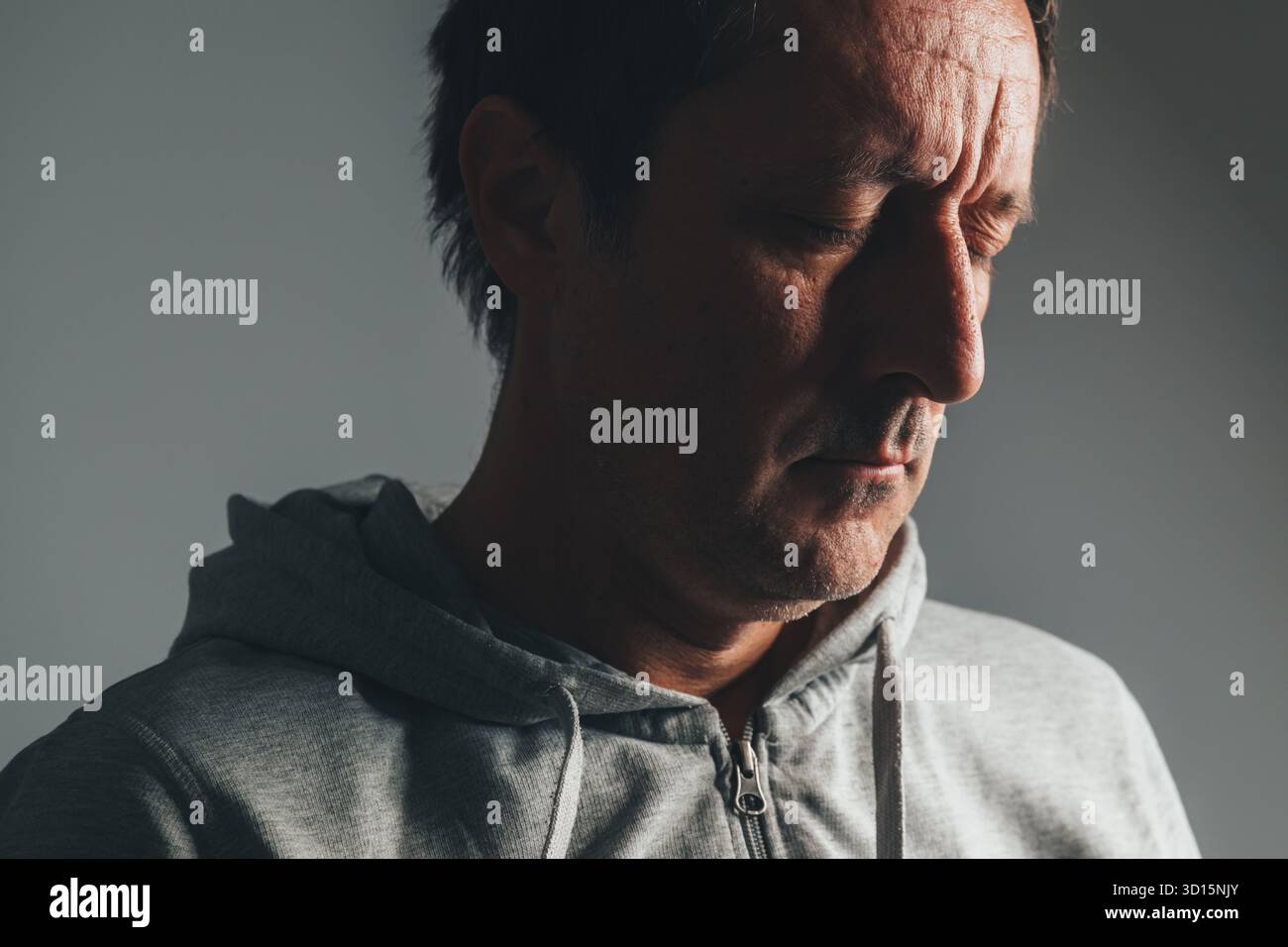 Ritratto basso di uomo maturo in abbigliamento casual con gli occhi chiusi, che esprime rammarico, tristezza e riflesso emotivo. Messa a fuoco selettiva. Foto Stock