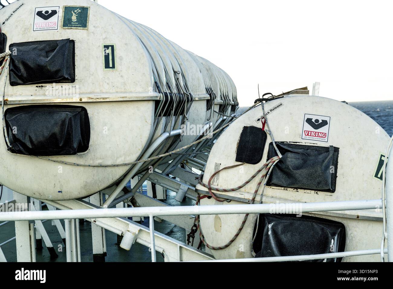 Barcellona, Catalogna - Spagna - 01-10-2025: Zattere di salvataggio bianche chiuse etichettate con numeri e contrassegni di sicurezza sono fissate sul ponte del traghetto, pronte per l'uso Foto Stock