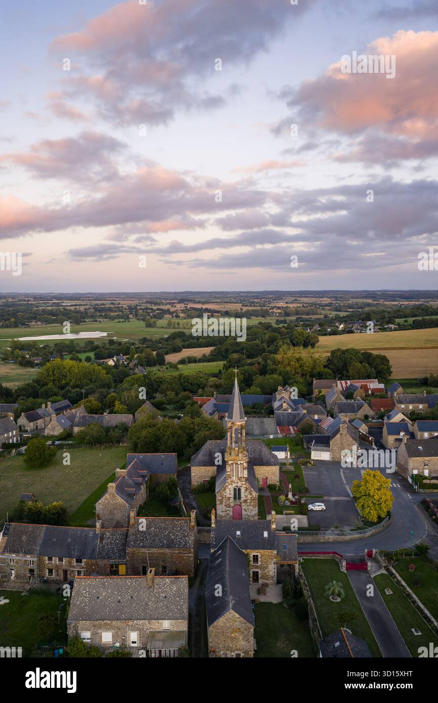 Il panorama dall'alto mostra un tranquillo villaggio con case in pietra, una guglia da chiesa e campi verdi. Sougeal, Bretagna, Francia Foto Stock