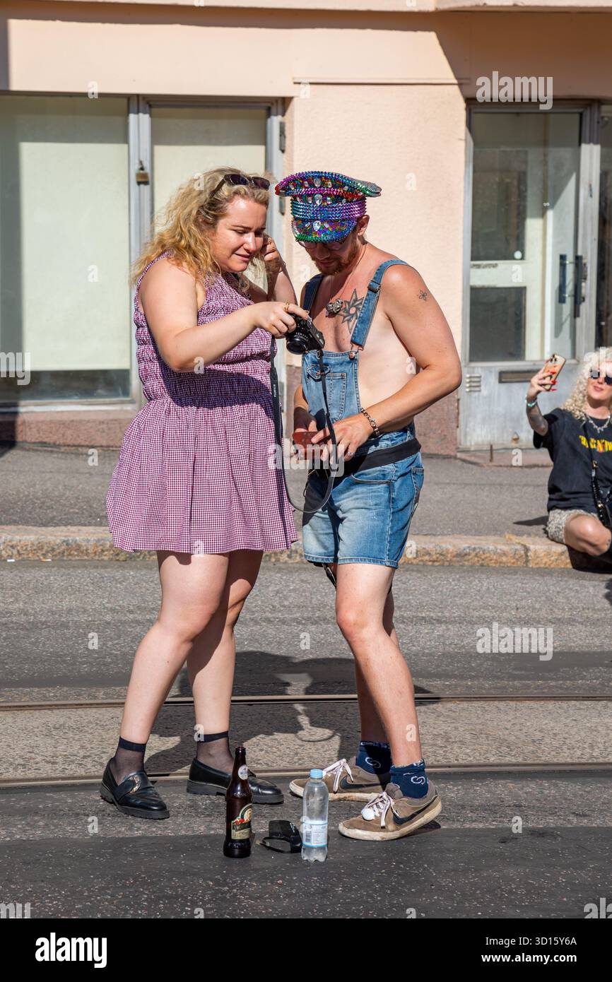 Amici che guardano le foto in macchina all'evento della comunità Kallio Block Party 2025 nel distretto Kallio di Helsinki, Finlandia Foto Stock