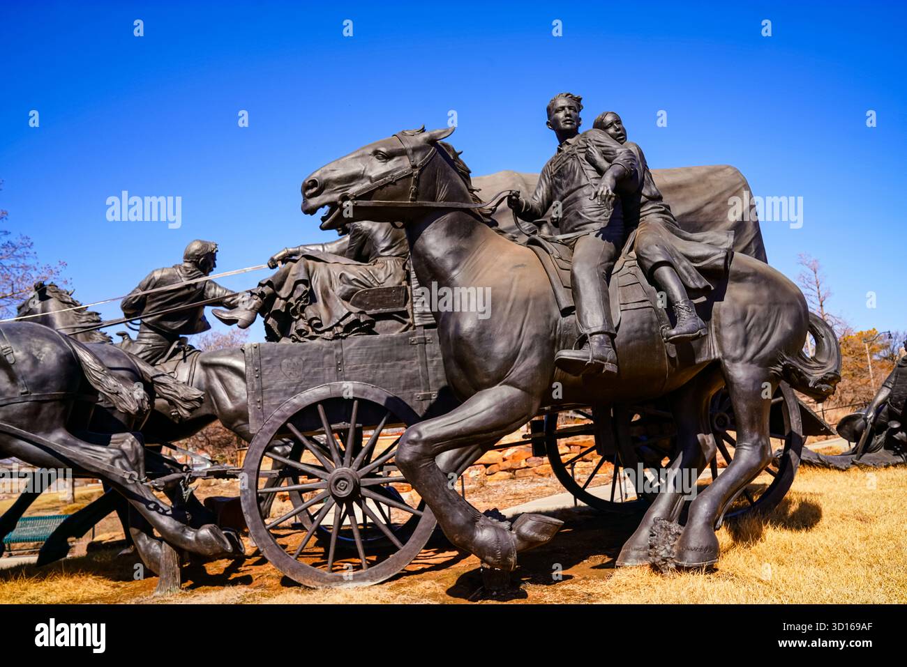 Scultura in bronzo di una famiglia pioniera che viaggia accanto a un carro coperto al Centennial Land Run Monument, in onore dei coloni storici dell'Oklahoma Foto Stock