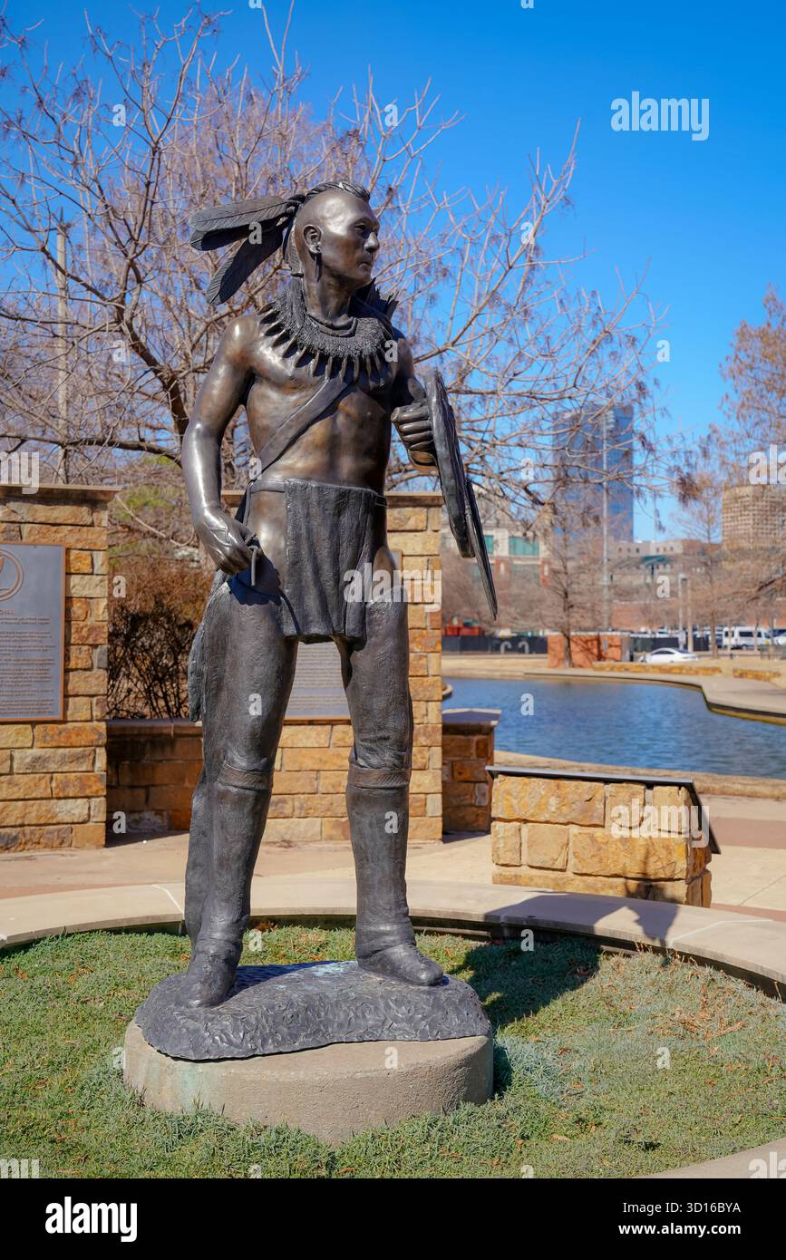 La statua del guerriero Chickasaw si trova vicino al Bricktown Canal, circondato da targhe che onorano la storia, la cultura e l'arte indigena in Oklahoma Foto Stock