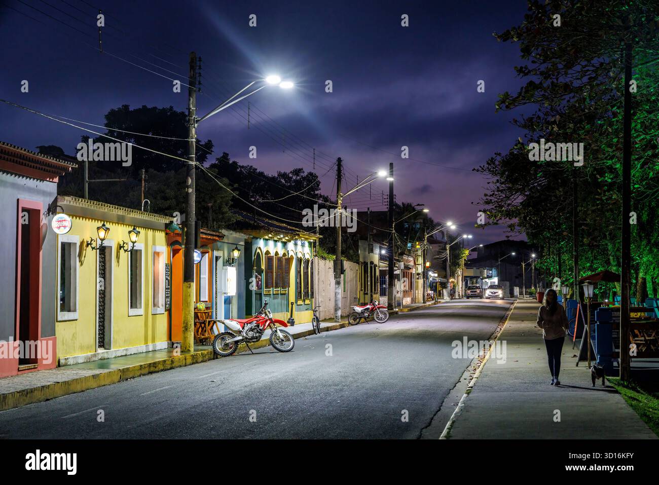 Donna che cammina da sola per strada di notte nel quartiere vecchio, Cananeia, Brasile Foto Stock