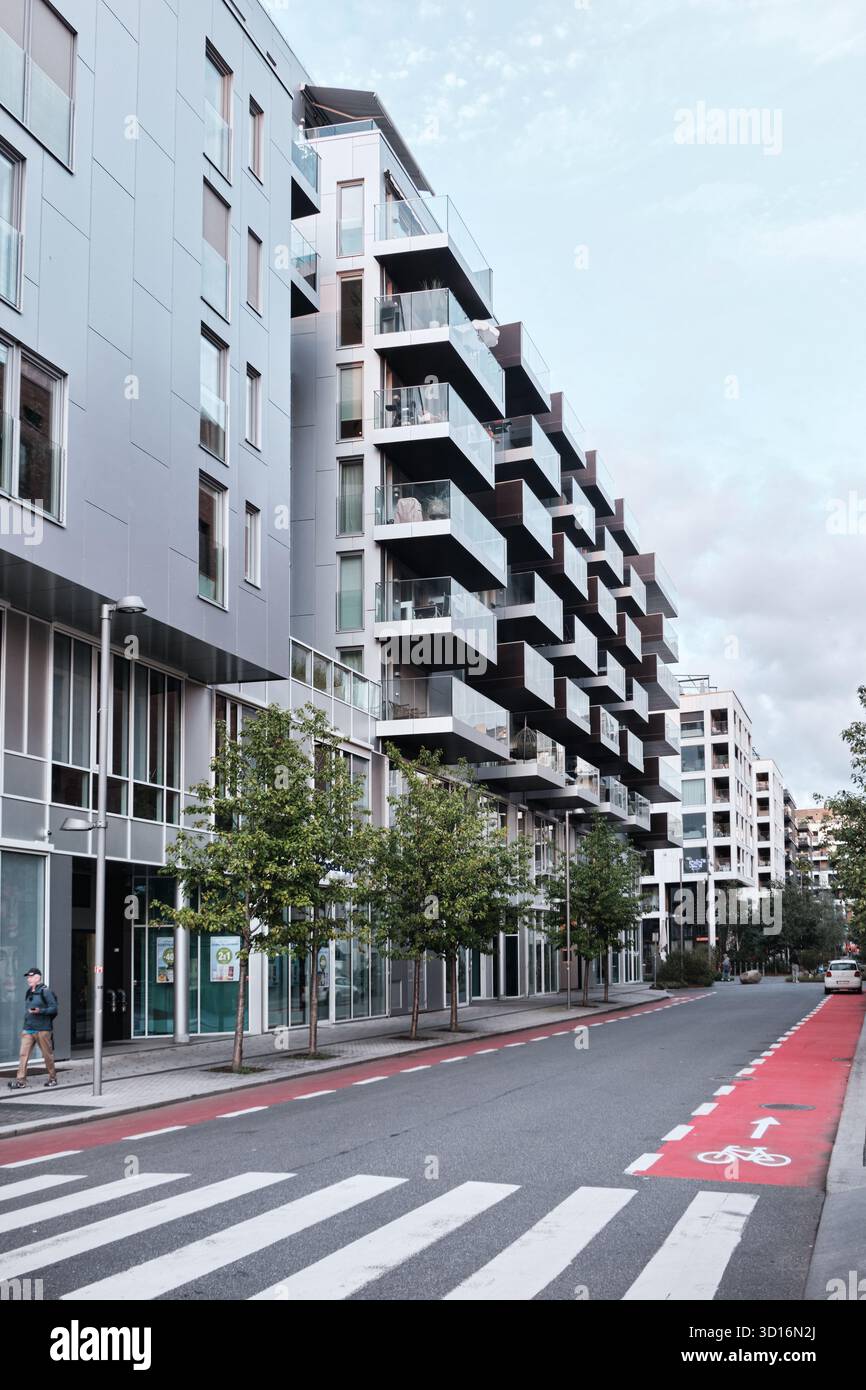 Oslo, Norvegia - 9 settembre 2025: La riqualificata Bjorvika nel centro di Oslo con un moderno blocco di appartamenti con balconi in vetro Foto Stock