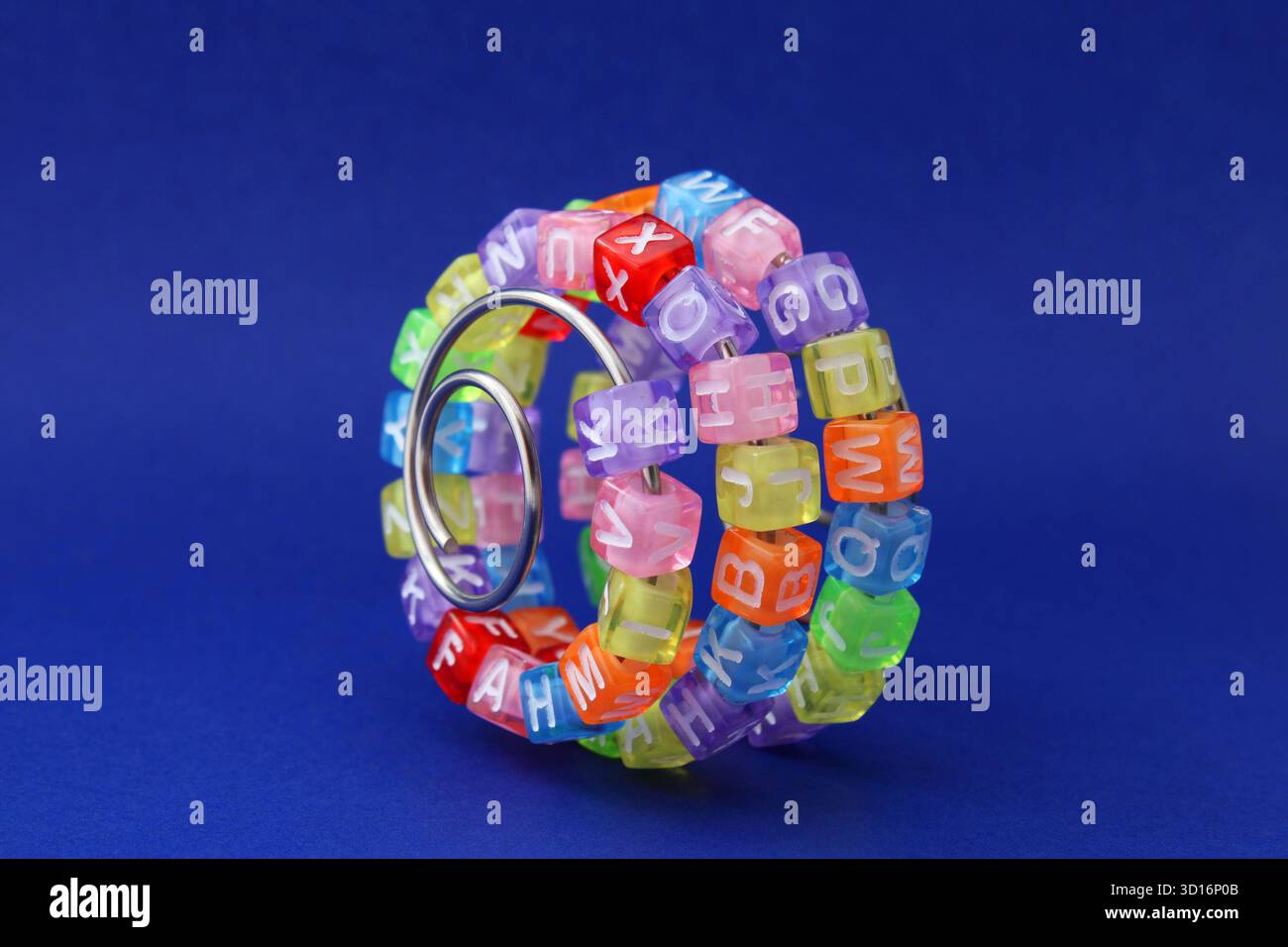 Curva di apprendimento, cubi colorati con lettere su una spirale metallica Foto Stock