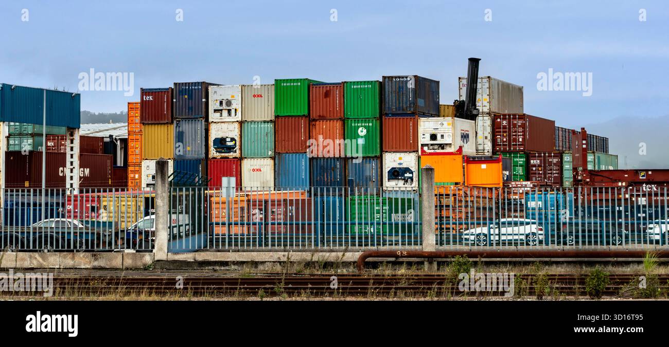 Container impilati in uno scalo merci, Vigo, Galizia, Spagna, che simboleggiano il commercio mondiale, logistica, trasporto merci e commercio marittimo. Foto Stock