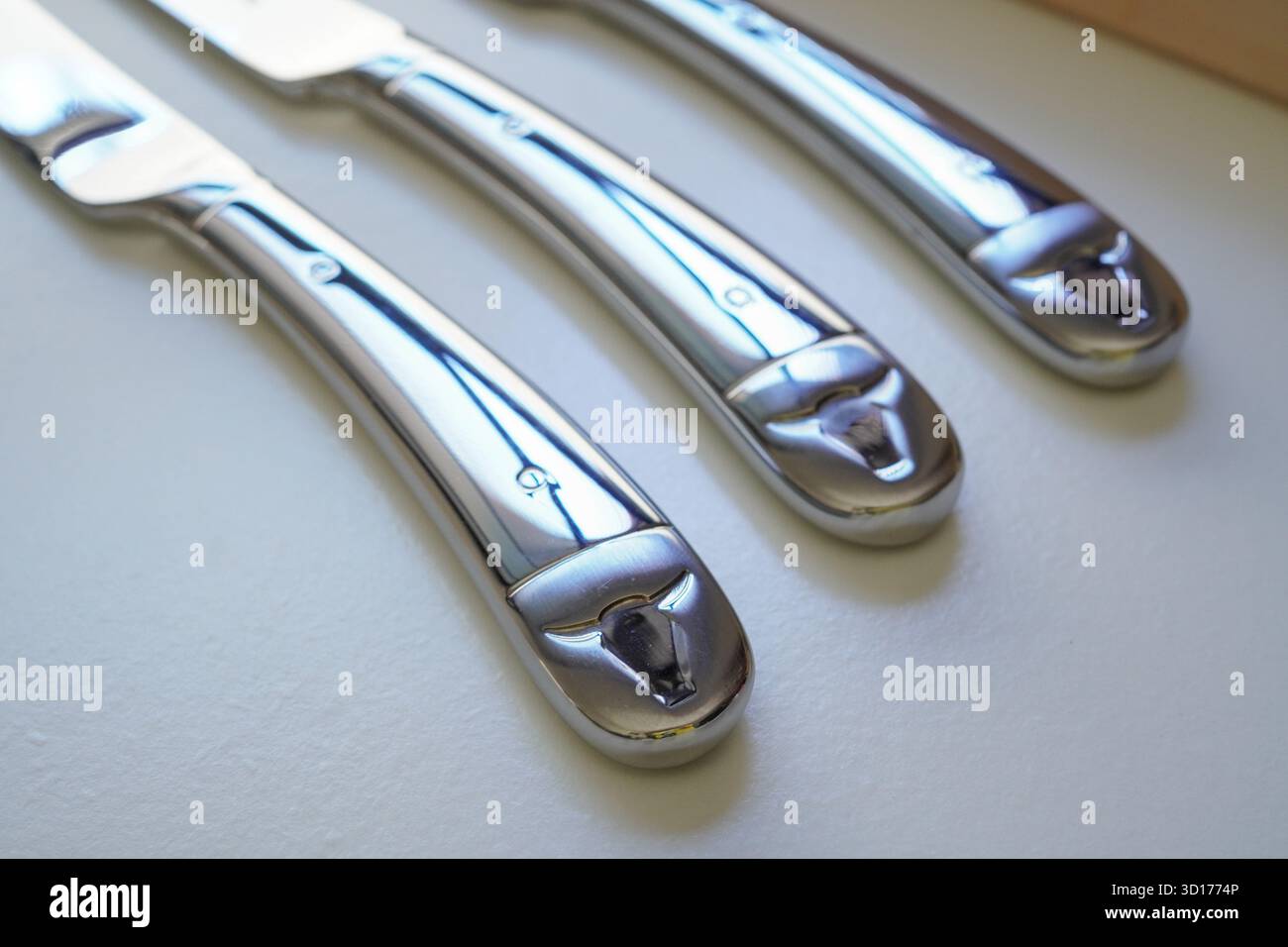 Primo piano di coltelli da bistecca incisi con il design di una mucca Foto Stock