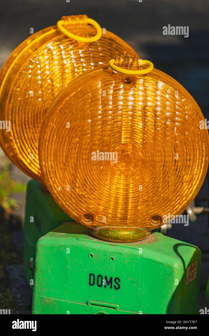 Due spie gialle luminose con basi verdi a terra Foto Stock