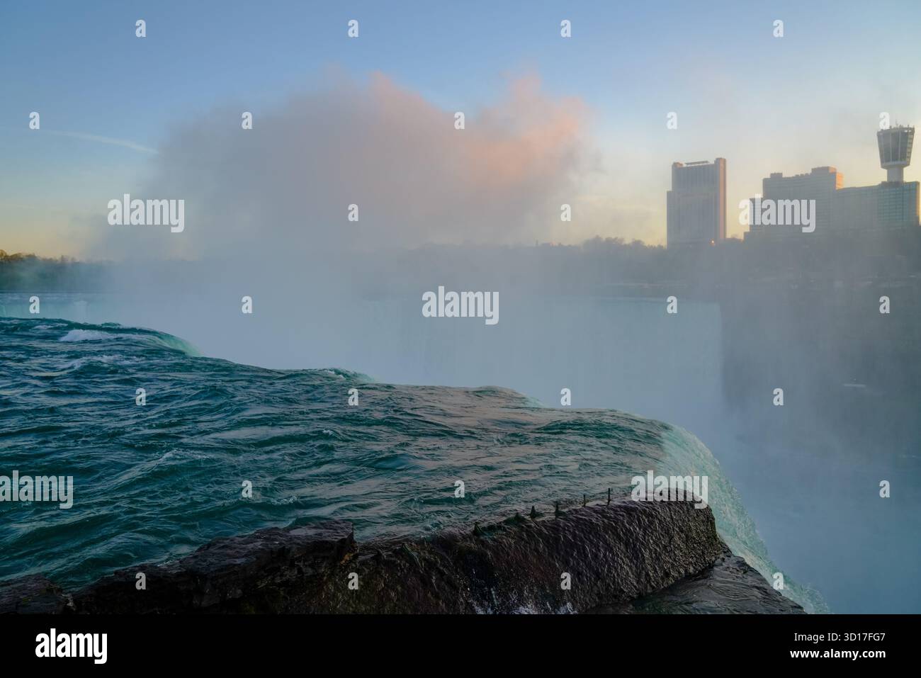La nebbia serale sorge dalle Horseshoe Falls sotto la luce soffusa del tramonto, mescolando la potente corrente e la foschia atmosferica in una serena vista naturale. Foto Stock