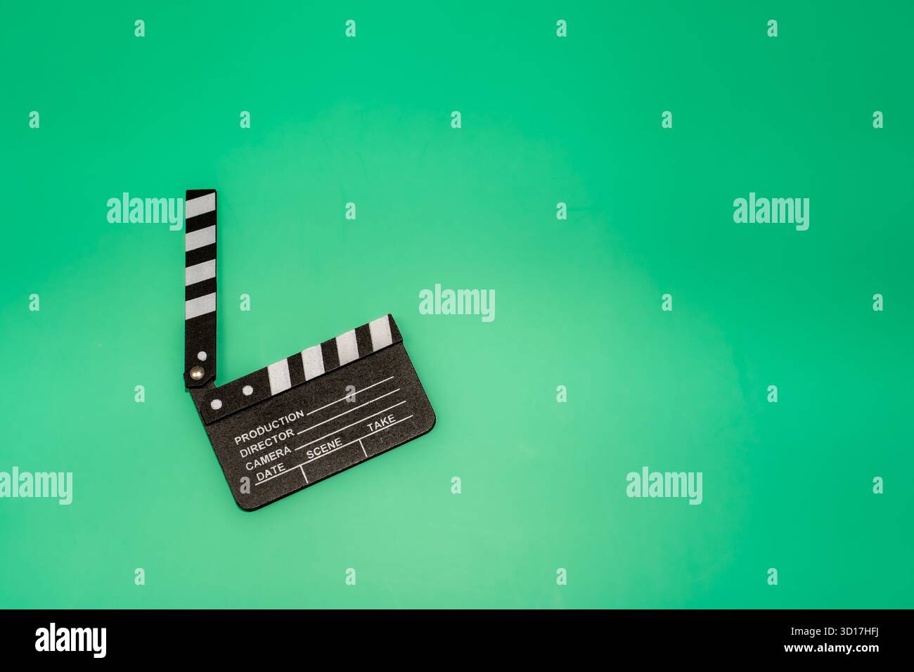 Il clapperboard di un film si trova su uno sfondo verde brillante, pronto per le riprese, perfetto per progetti a tema cinematografico. Foto Stock