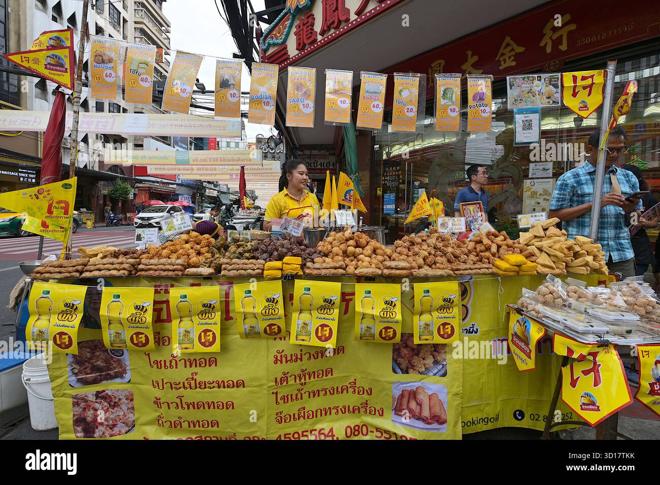 Venditore ambulante che vende una varietà di piatti vegetariani fritti e cotti in profondità al Yaowarat Vegetarian Festival del 2025 a Chinatown, Bangkok Foto Stock