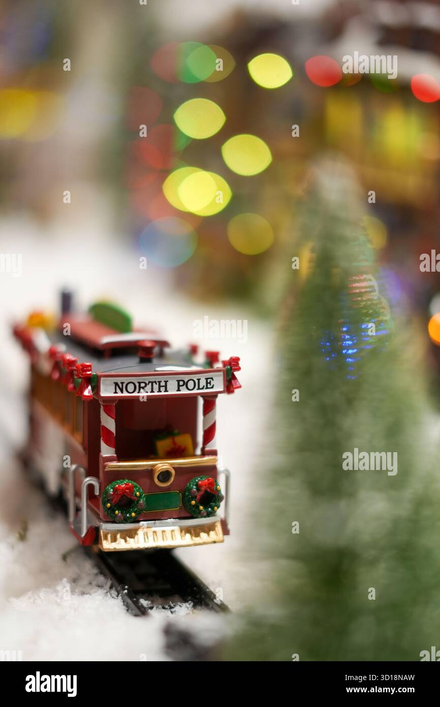 Il trenino bizzarro del Polo Nord brilla di magia innevata, ricoperto di ghirlande e luci scintillanti: Puro fascino natalizio. Foto Stock