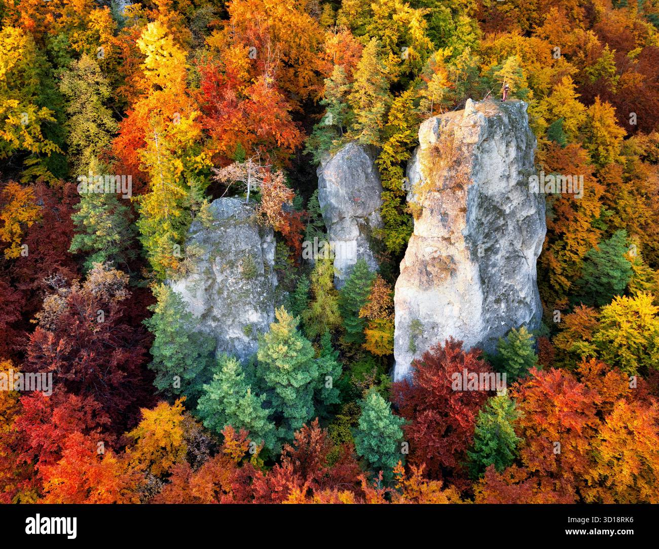 Uomo fotografo in montagna in autunno al tramonto Foto Stock