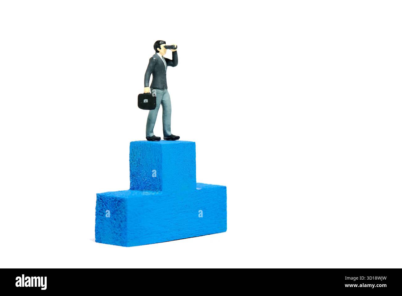 Fotografia di figure giocattolo in miniatura. Illustrazione del concetto tattico vincente. Un uomo d'affari che usa un telescopio binoculare sopra il podio blu Foto Stock