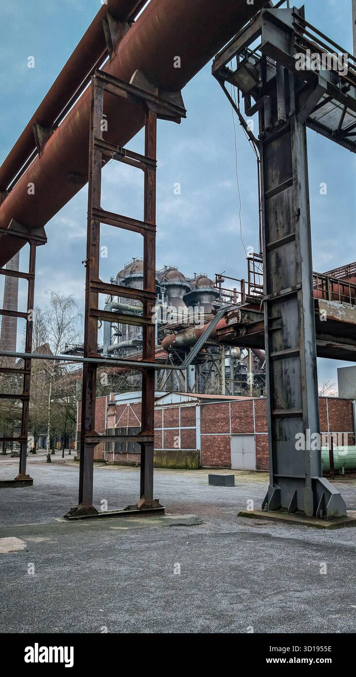 Geometria industriale con travi e tubi in metallo intersecanti nella vecchia fabbrica. Foto Stock