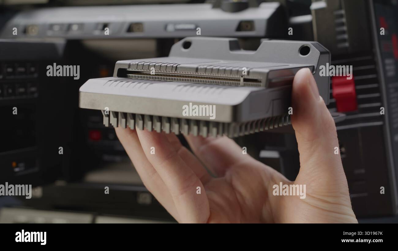 Una mano esperta posiziona con precisione un modulo elettronico complesso. Foto Stock