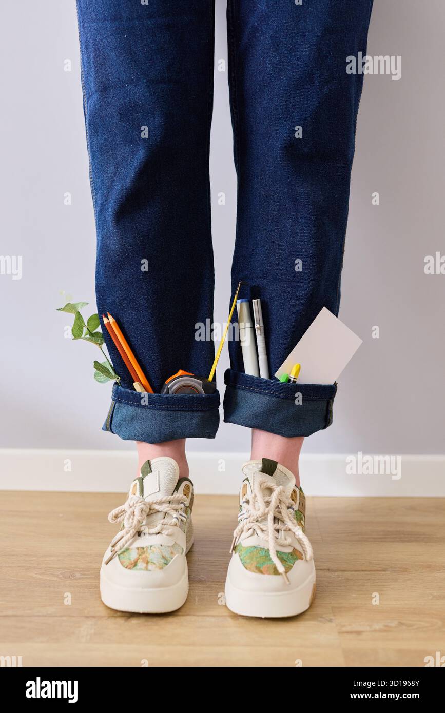 Attività creative di giardinaggio e arte con attrezzi in pantaloni in denim arrotolati Foto Stock