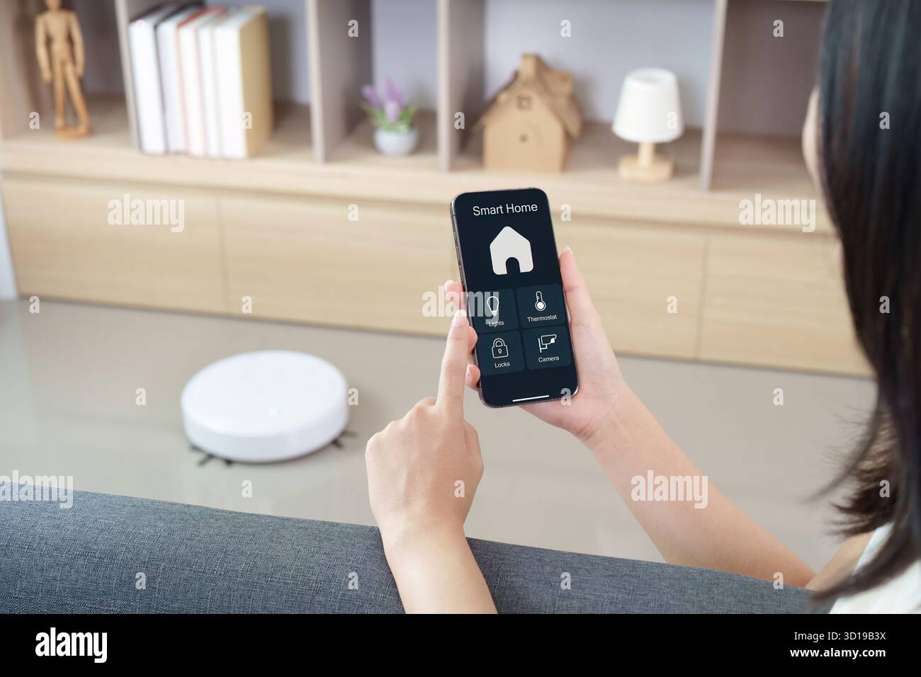 Gestione domestica intelligente. Utente che controlla i dispositivi con l'app per smartphone. Foto Stock