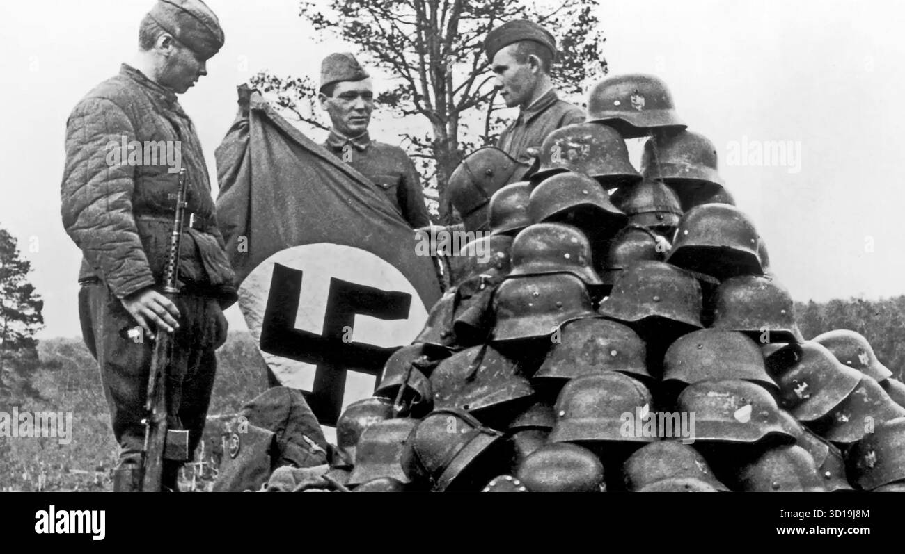 Soldati russi con caschi nazisti catturati e una bandiera intorno al 1943. Foto: SIB Foto Stock
